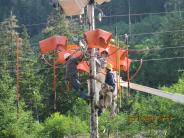 The linemen are installing new cutouts on the Log Cabin switch, summer 2013. Linemen working on power lines and pole.