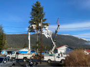 May 2021 on Wrangell Ave, the linemen are replacing a broken crossarm on the utility pole. Bucket trucks and linemen working on power lines.